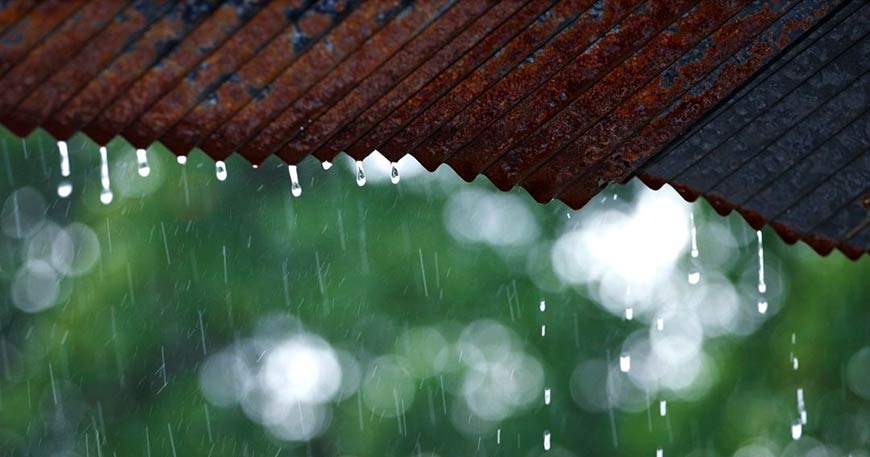 Photo of rain dripping off a metal roof